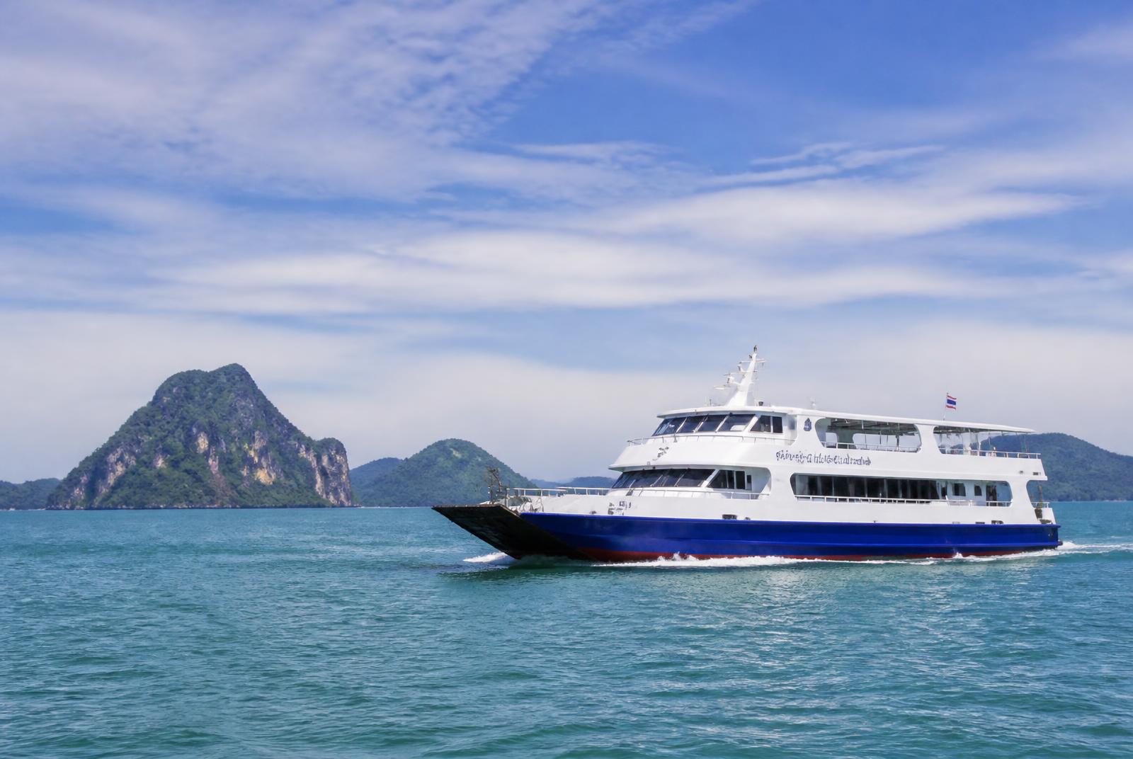 Passenger ferry crossing calm turquoise water between Thai islands on a clear day